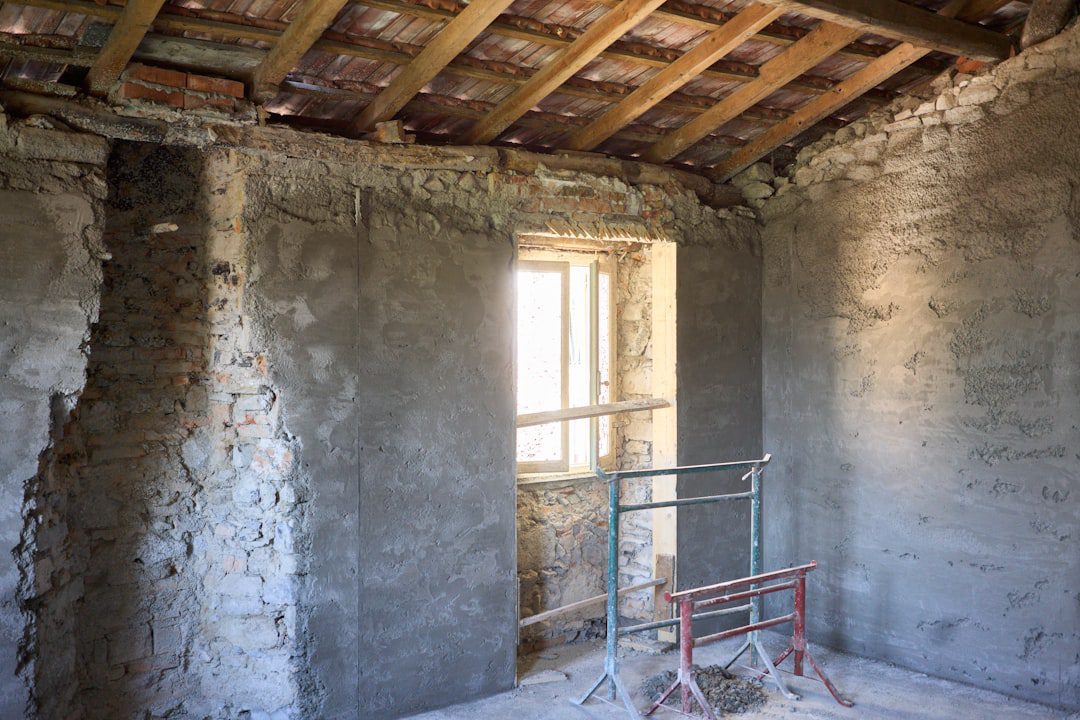 Guide pratique 2026 : comment bien choisir son isolation thermique 1 Artisan posant une isolation thermique sur les murs intérieurs d'un logement en rénovation