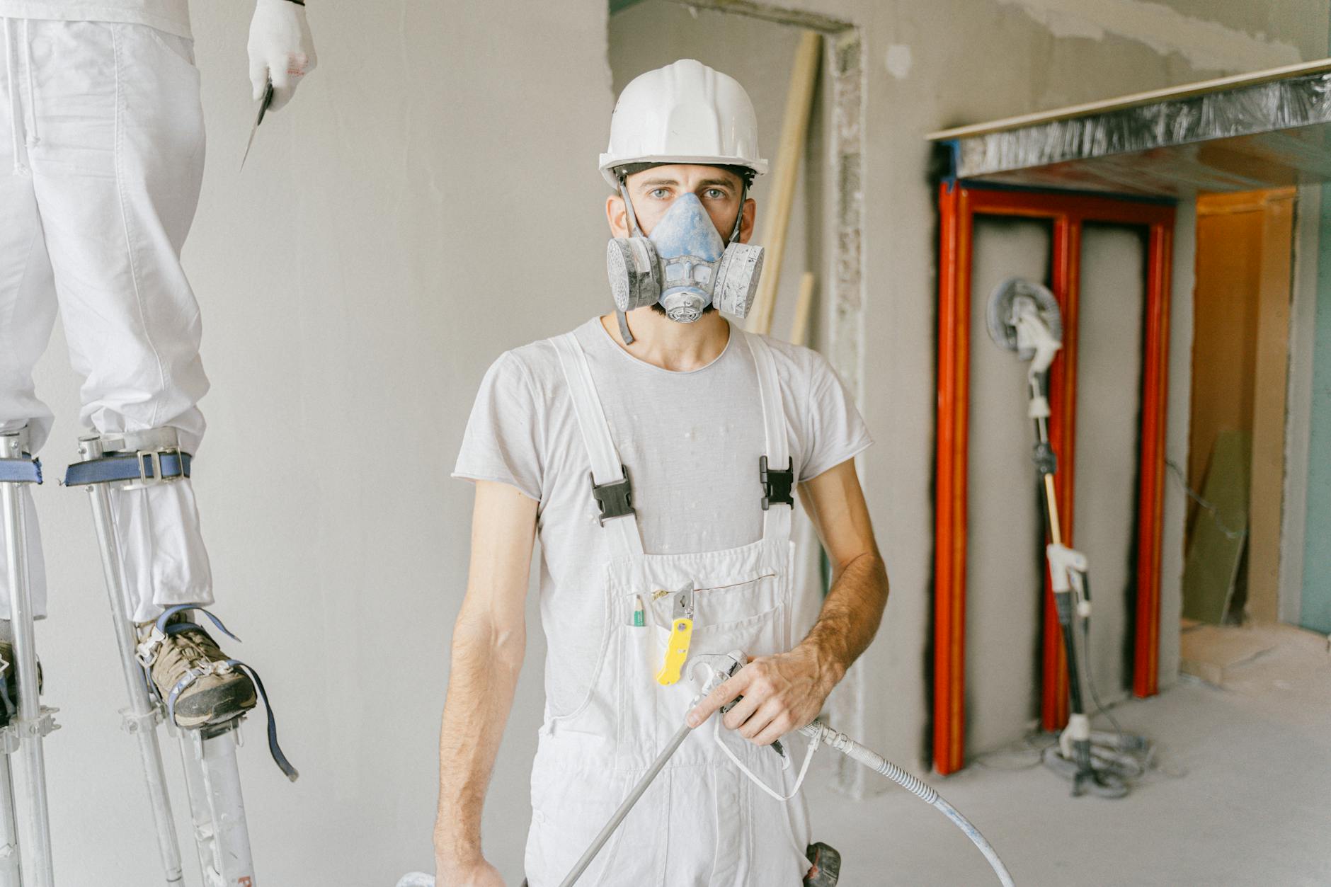 Guide complet MaPrimeRénov' 2025 : 5 aides essentielles pour financer votre rénovation 3 Artisan plaquiste posant une isolation thermique intérieure sur un chantier de rénovation